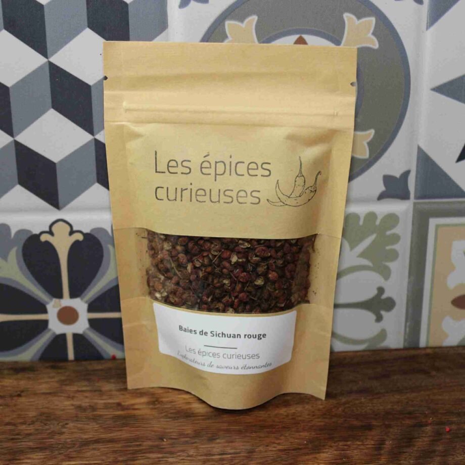 Sachet de baies de Sichuan rouge Les épices curieuses, posé sur fond de carrelage décoratif.