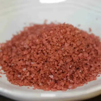 Sel rouge d'Hawaï sur une assiette blanche, utilisé pour sa saveur unique et ses bienfaits nutritionnels.