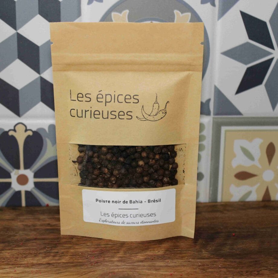 Sachet de poivre noir de Bahia par Les Épices Curieuses, sur fond de tuiles décoratives.