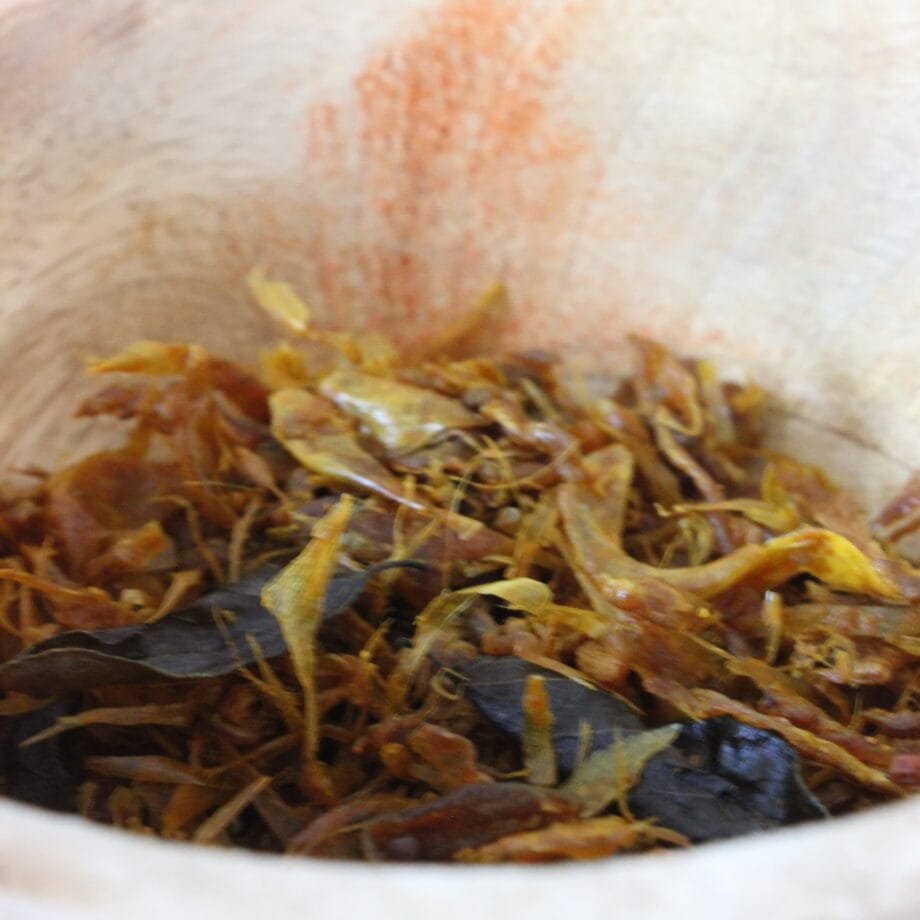 Mélange d'épices séchées dans un bol en bois, prête pour la cuisine ou l'assaisonnement.