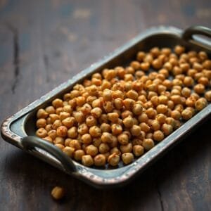 Pois chiches grillés sur un plateau en métal. Snack sain et riche en protéines, idéal pour une collation nourrissante.