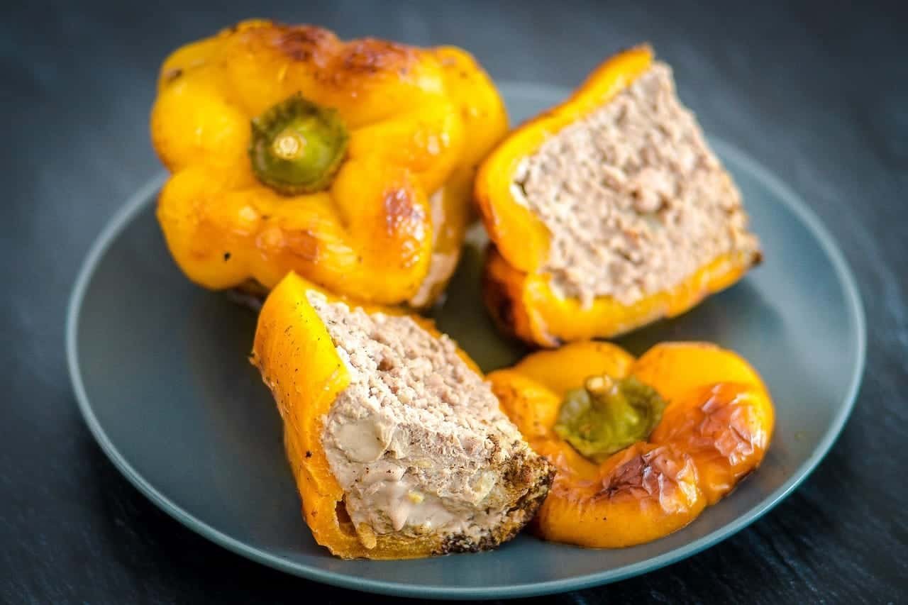 Poivrons jaunes farcis au four, servis sur une assiette grise pour un repas savoureux et coloré.