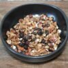 Bol de muesli aux fruits séchés et noix, parfait pour un petit-déjeuner sain et énergisant.