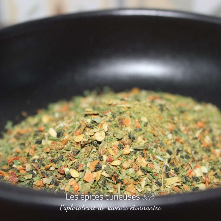 Mélange d'épices colorées dans un bol noir pour rehausser vos plats favoris.