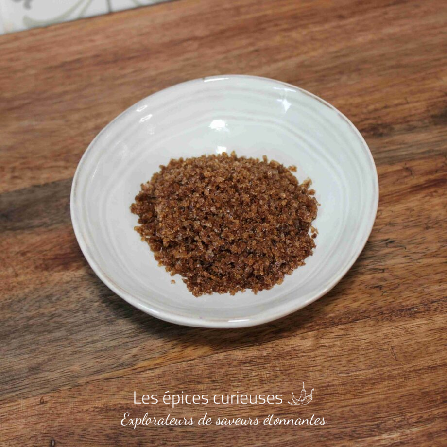 Bol de sucre brun sur une table en bois.