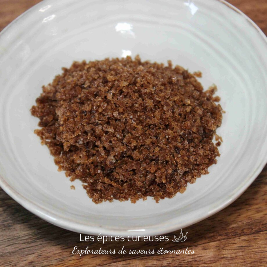 Un bol de cassonade brune sur une table en bois, idéal pour les recettes de pâtisserie.