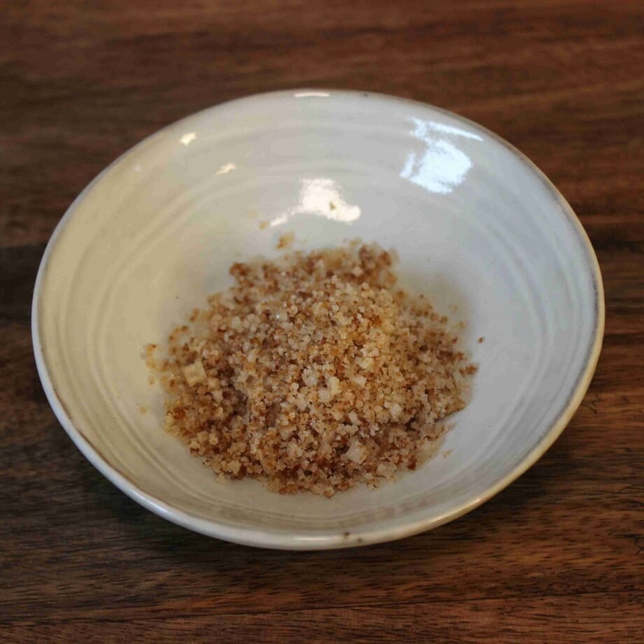 Assiette de sel fumé artisanal sur une table en bois, idéal pour relever les plats.