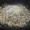 Sel aromatisé aux herbes sur fond noir, idéal pour rehausser la saveur des plats.