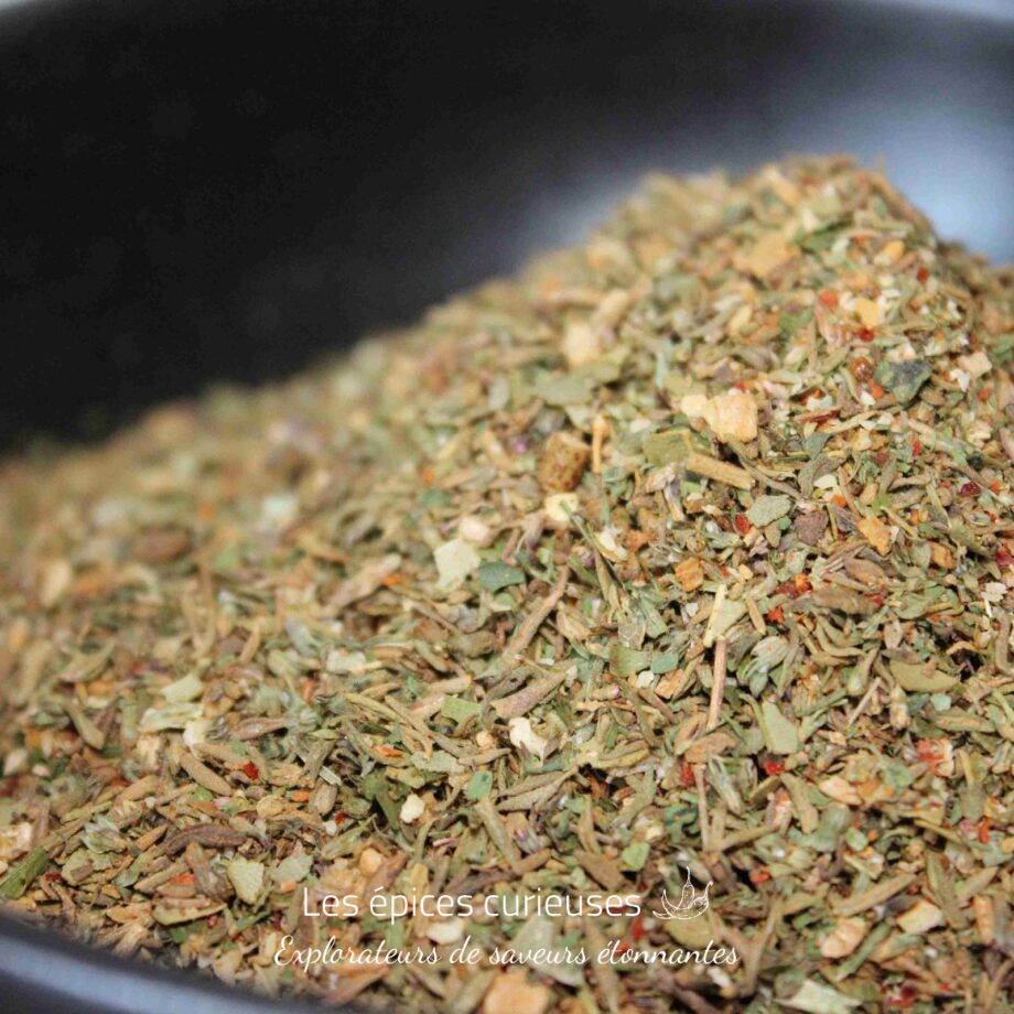 Mélange d'épices séchées dans un bol noir, idéal pour assaisonner vos plats méditerranéens.