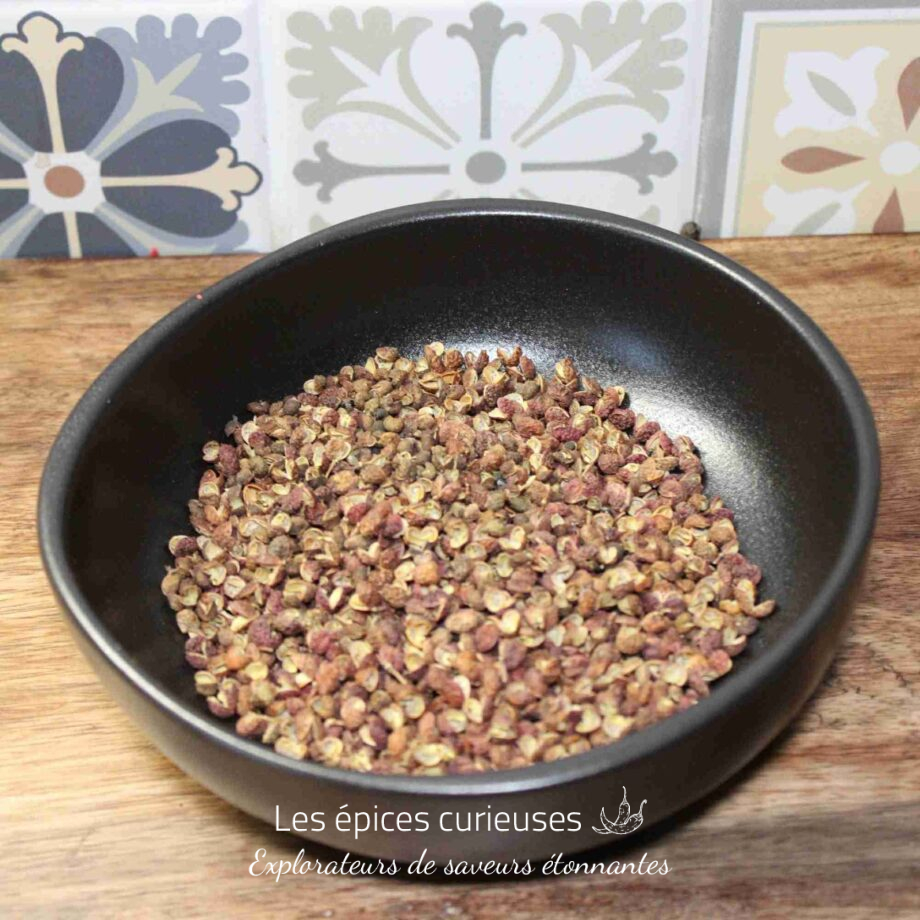 Bol de poivre de Sichuan sur fond de carreaux colorés dans une cuisine rustique.