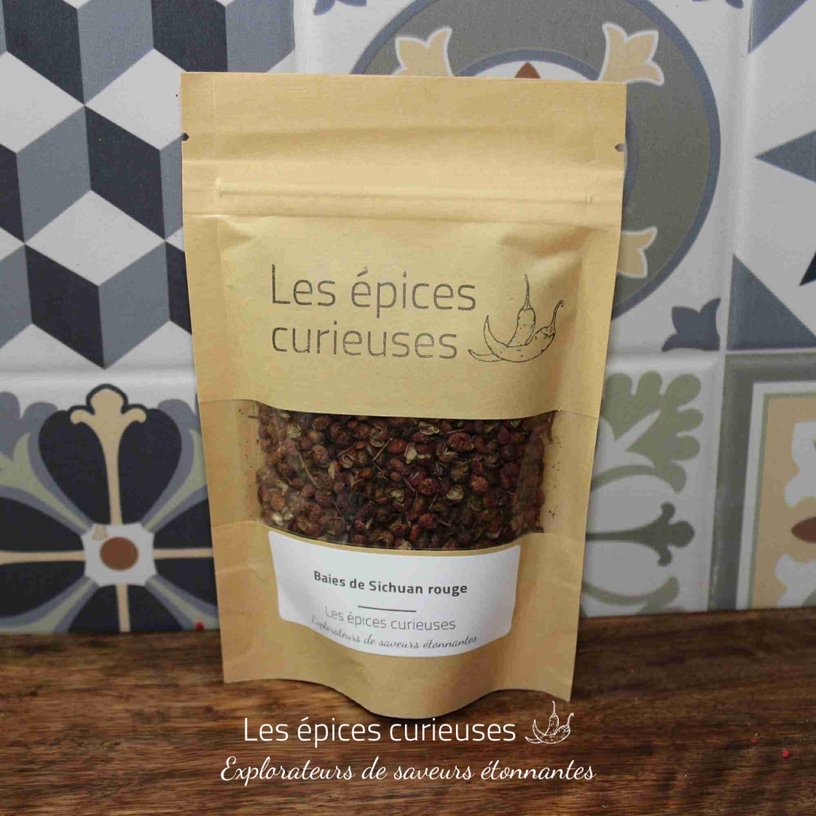 Sachet de baies de Sichuan rouge Les épices curieuses, posé sur fond de carrelage décoratif.
