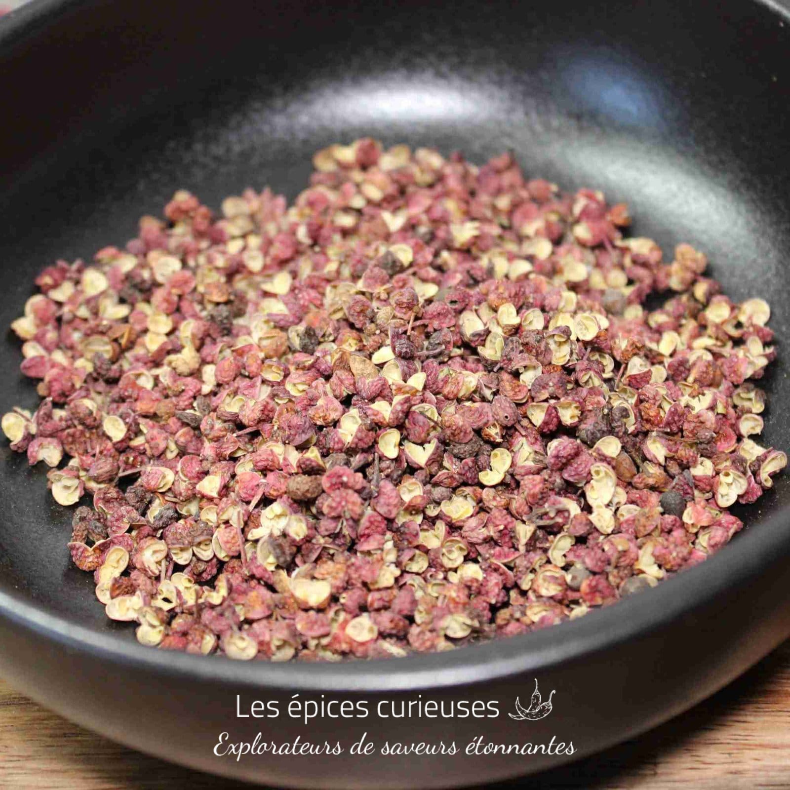 Grains de poivre de Sichuan dans un bol noir, épice asiatique pour relever vos plats avec une saveur unique et piquante.
