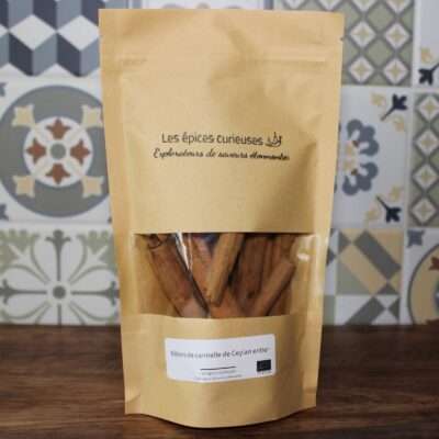 Paquet de bâtons de cannelle de Ceylan entier Les épices curieuses sur une table en bois, fond de carreaux.