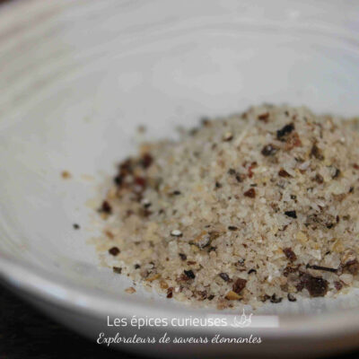 Mélange de sel épicé dans un bol blanc, idéal pour rehausser les saveurs culinaires.