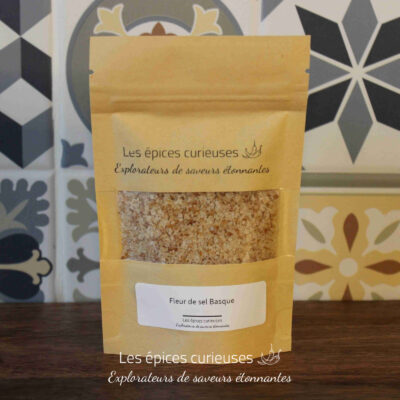 Paquet de fleur de sel basque Les épices curieuses sur fond de carreaux décoratifs.