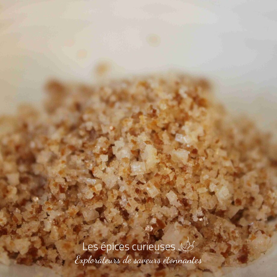 Gros plan de sucre roux naturel brillant sur fond clair.