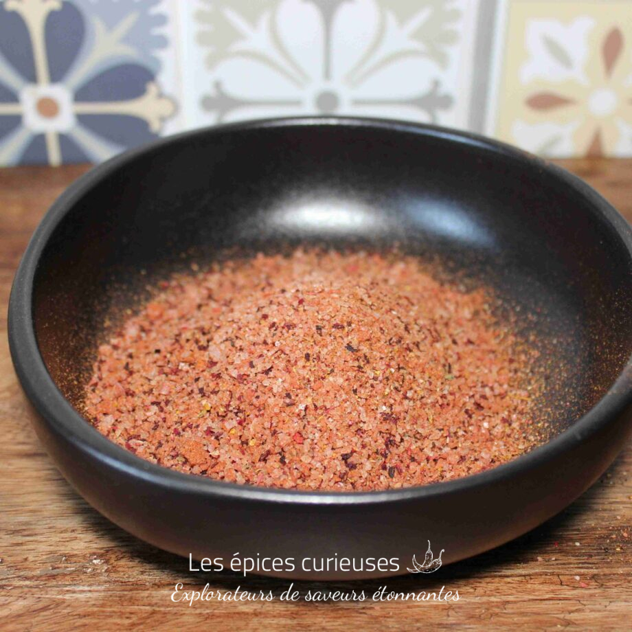 Sel rose de l'Himalaya dans un bol noir sur fond de carreaux décoratifs.