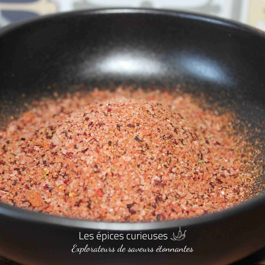 Sel rose épicé dans un bol noir pour rehausser vos plats culinaires avec une touche exotique et savoureuse.