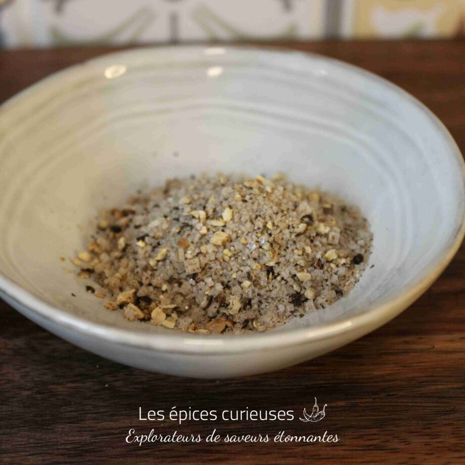 Assortiment de sel épicé dans un bol en céramique, idéal pour rehausser les saveurs de vos plats.