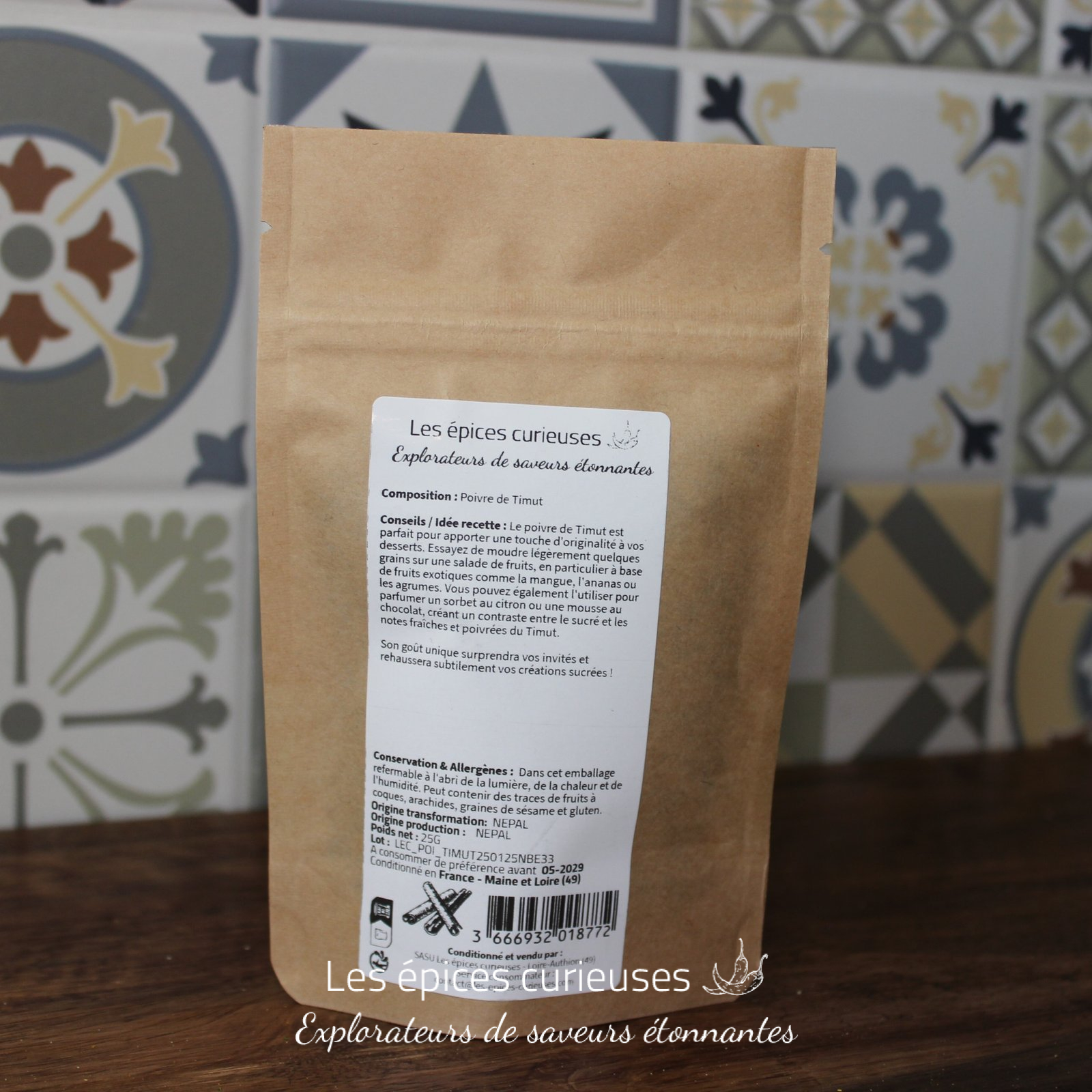 Paquet de poivre de Timut, épices curieuses, sur fond de carreaux décoratifs.