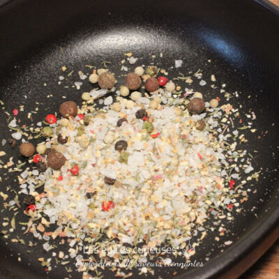 Mélange d'épices et de sel dans une poêle noire pour rehausser vos plats avec saveurs et arômes.