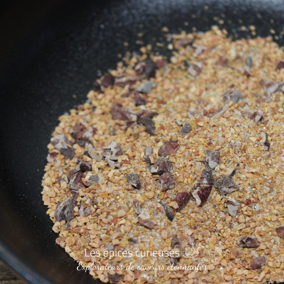 Gros sel et assaisonnements variés dans un bol noir prêts pour la cuisine.