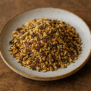 Assiette de granulés d'épices et herbes aromatiques sur fond de table en bois.