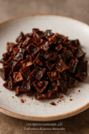 Morceaux de piment séché sur une assiette blanche, parfaits pour rehausser vos plats avec une touche épicée.