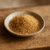 Bol de sucre brun sur une table en bois, idéal pour des recettes naturelles et savoureuses.