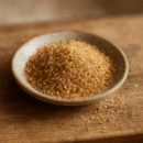 Bol de sucre brun sur une table en bois, idéal pour des recettes naturelles et savoureuses.