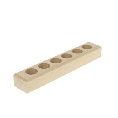 Bloc en bois clair avec sept cavités circulaires pour billes Montessori.