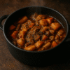 Ragoût de légumes mijoté dans une cocotte noire, parsemé d'épices pour un repas réconfortant et savoureux.