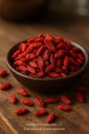 Bol de baies de goji rouges sur une table en bois, mise en avant de leurs bienfaits santé et propriétés antioxydantes.