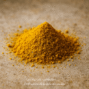 Tas de curcuma en poudre sur une surface en bois, épice utilisée pour ses bienfaits et ses saveurs culinaires.