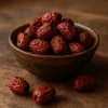 Bol de jujubes séchés sur une table en bois, fruits riches en nutriments et bienfaits pour la santé.