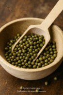 Boulettes de poivre vert dans un bol en bois avec une cuillère, détail de cuisine épicée.
