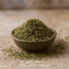 Bol en terre cuite rempli d'herbes séchées vertes sur une surface en bois. Assaisonnement aromatique.
