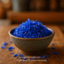 Bol en céramique rempli de fleurs de bleuet séchées sur une table en bois. Idéal pour la décoration ou l'infusion.