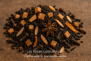 Mélange d'épices : anis étoilé, clous de girofle et fruits secs sur fond de bois, pour infusion ou cuisine.