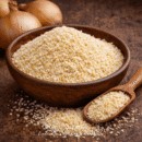 Bol d'oignons séchés en flocons avec cuillère en bois, idéal pour rehausser vos plats.