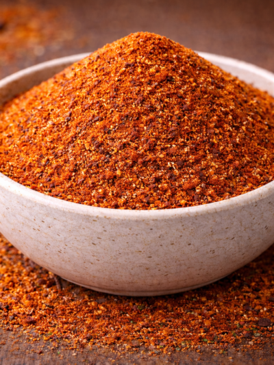 Bol de mélange d'épices colorées sur une table en bois, prêt pour sublimer vos plats.