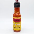 Bouteille de sauce piquante extrême avec étiquettes de danger et avertissements. Usage réservé aux amateurs de piments forts.