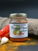 Purée de piment ananas Maison Boyer, fabriquée en France, pot épicé avec ingrédients frais en arrière-plan.