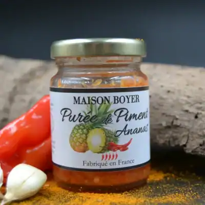 Purée de piment ananas Maison Boyer, fabriquée en France, pot épicé avec ingrédients frais en arrière-plan.