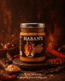 Pot de sauce piquante Haban's entouré de piments, idéale pour relever vos plats avec saveur et intensité.