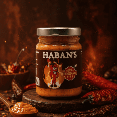 Pot de sauce piquante Haban's entouré de piments, idéale pour relever vos plats avec saveur et intensité.