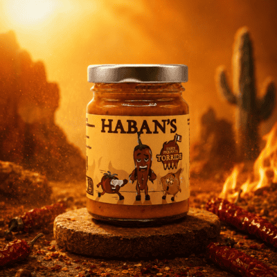 Pot de sauce piquante Haban's, ambiance désert ardent, piments et feu en arrière-plan.